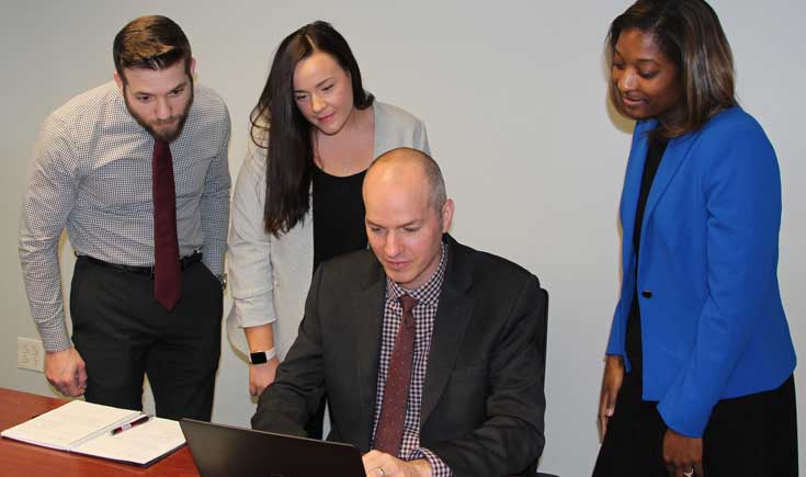 Ray Davis and team looking at laptop