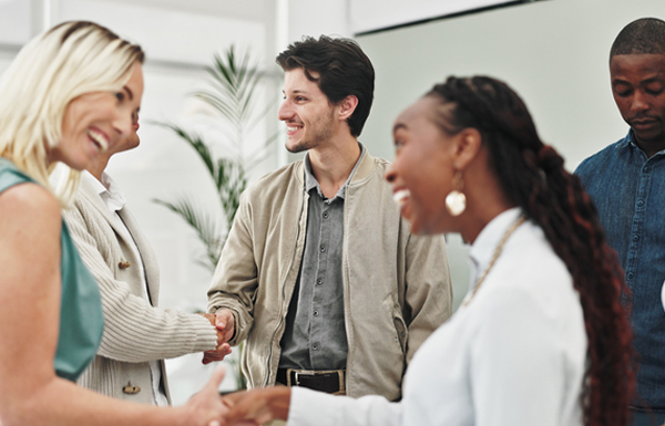 GettyImages-2151270253 group of people standing and networking, meeting one another