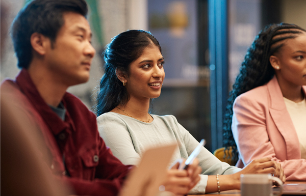 GettyImages-2153027163 Smiling young businesswoman amidst coworkers
